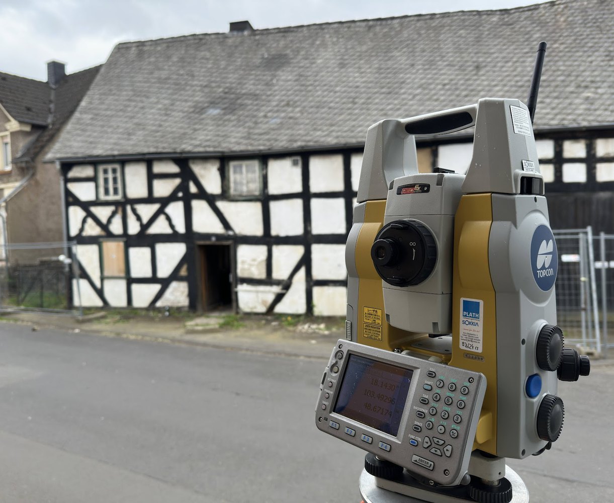 Tachymeter vor historischem Fachwerkgebäude